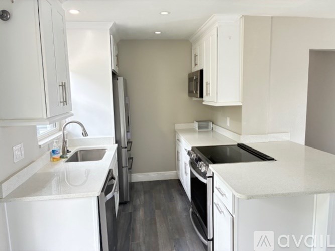 A kitchen with white appliances and cabinets.