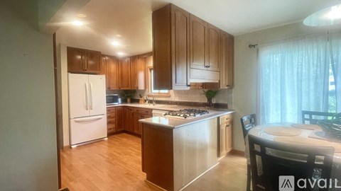 A kitchen with wooden cabinets and a white fridge.