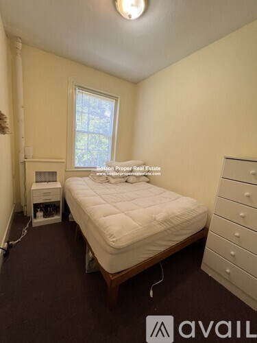 A bedroom with a bed, dresser, and window.