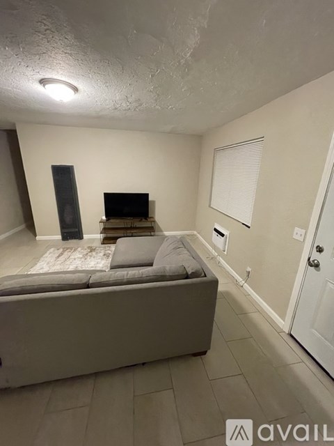 A bedroom with a bed, a dresser, and a door.