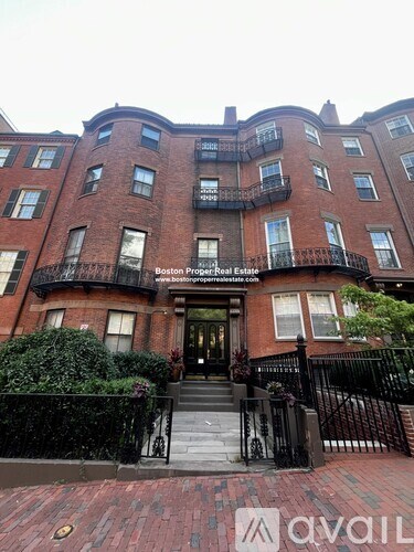 A brick building with a black fence in front.