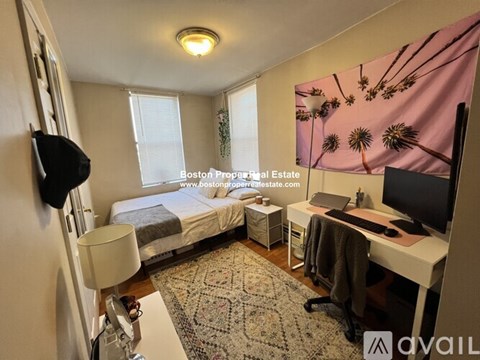 A bedroom with a bed, desk, and chair.