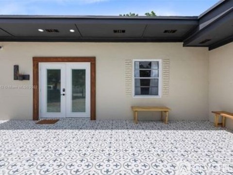 A house with a tiled floor and a bench outside.