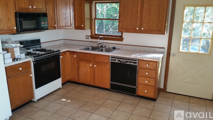 A kitchen with wooden cabinets and a stainless steel sink.
