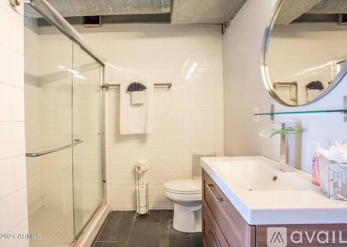 A bathroom with a toilet, sink, and shower.