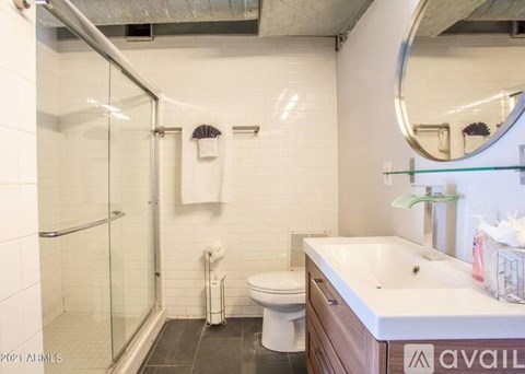 A bathroom with a toilet, sink, and shower.