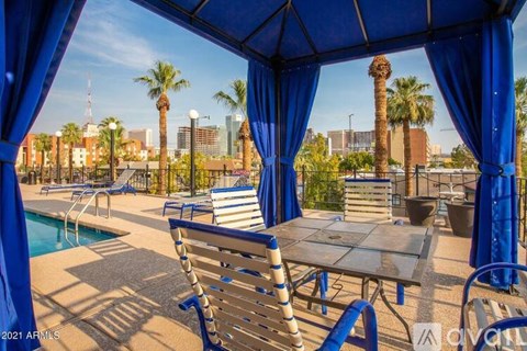 A poolside area with a table and chairs under a blue canopy.