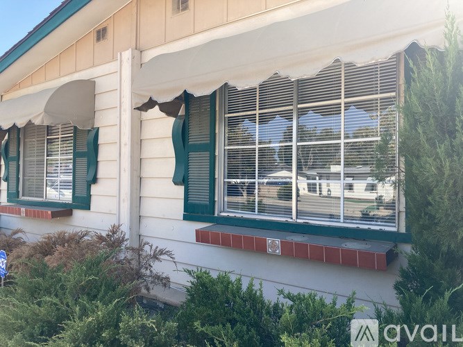 A building with green shutters and a white awning.