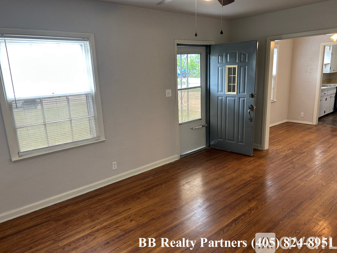 A room with a blue door and wooden floors is on the market with BB Realty Partners.