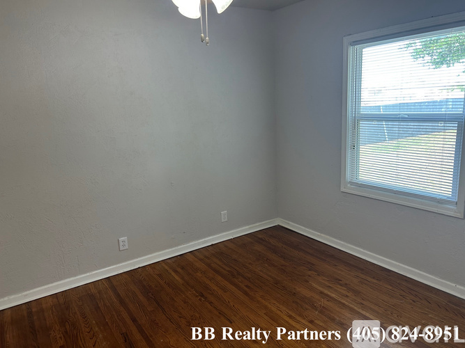 A room with a window and wooden flooring is on the market with BB Realty Partners.