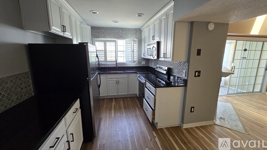 A kitchen with black countertops and white cabinets.