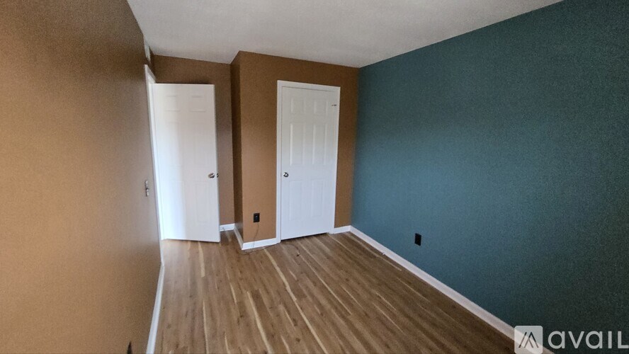A room with brown walls and a wooden floor.