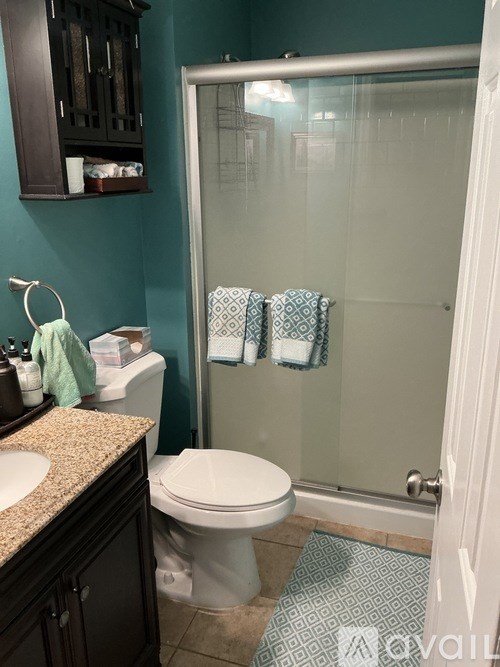 A bathroom with a toilet, sink, and shower.