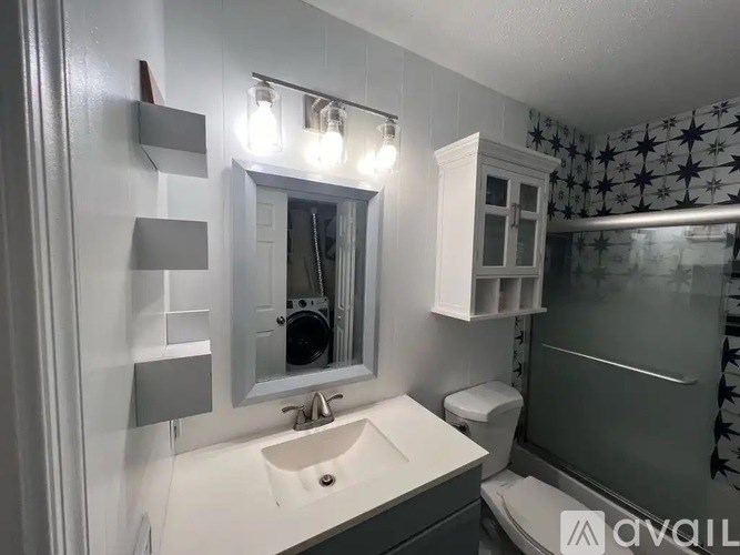A bathroom with a sink, mirror, and toilet.