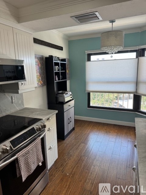 A kitchen with a black stove top oven and a black refrigerator.