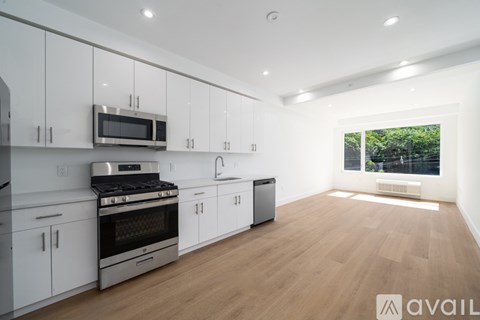 A modern kitchen with white cabinets and stainless steel appliances.