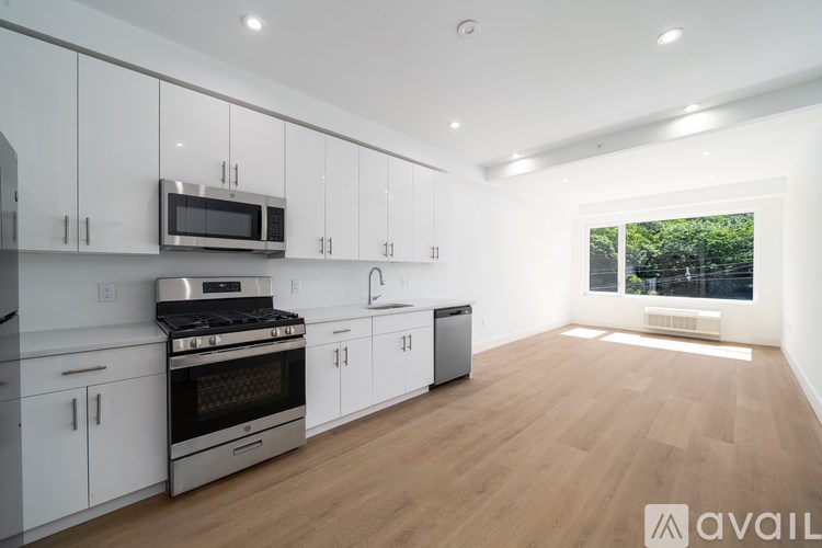 A modern kitchen with white cabinets and stainless steel appliances.