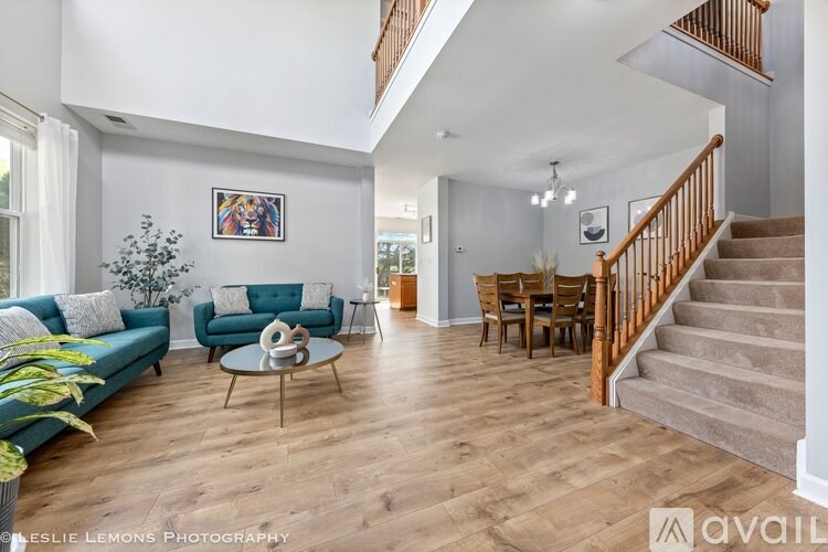 A living room with a staircase and a dining table.