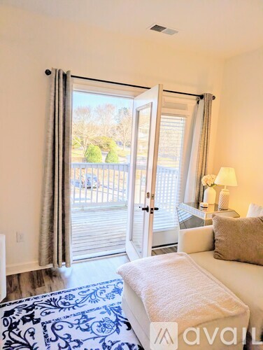 A bedroom with a white couch and a blue patterned rug.