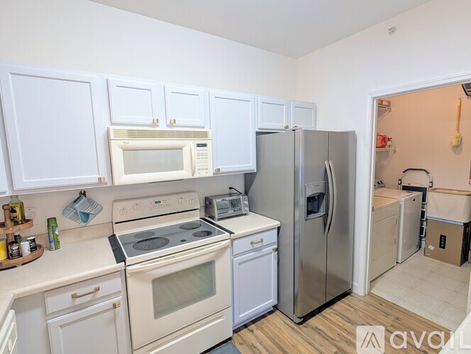 A kitchen with white cabinets and appliances.