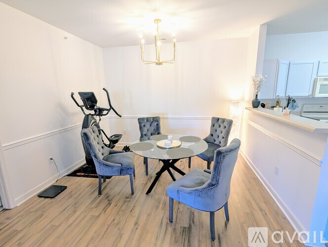 A dining area with a table and chairs and a baby stroller.
