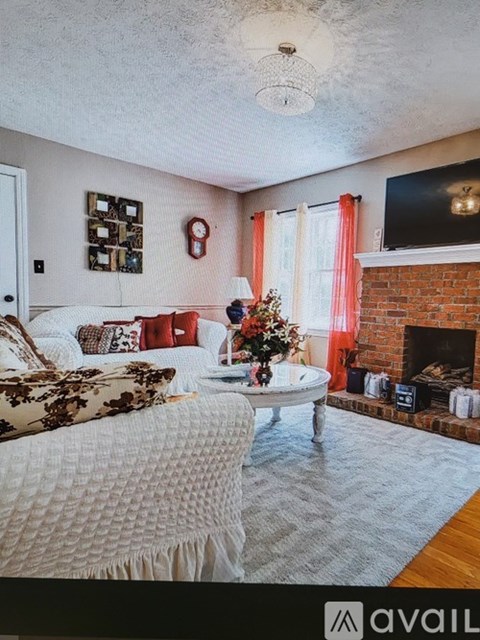 A living room with a white couch and a fireplace.