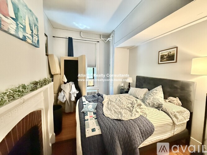 A bedroom with a large bed and a fireplace.