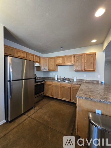 A kitchen with wooden cabinets and a granite countertop.