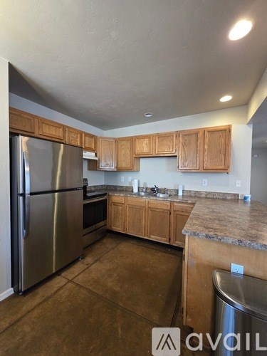 A kitchen with wooden cabinets and a granite countertop.