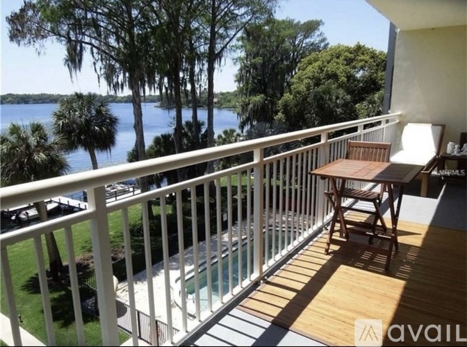 A balcony with a table and chairs overlooking a body of water.