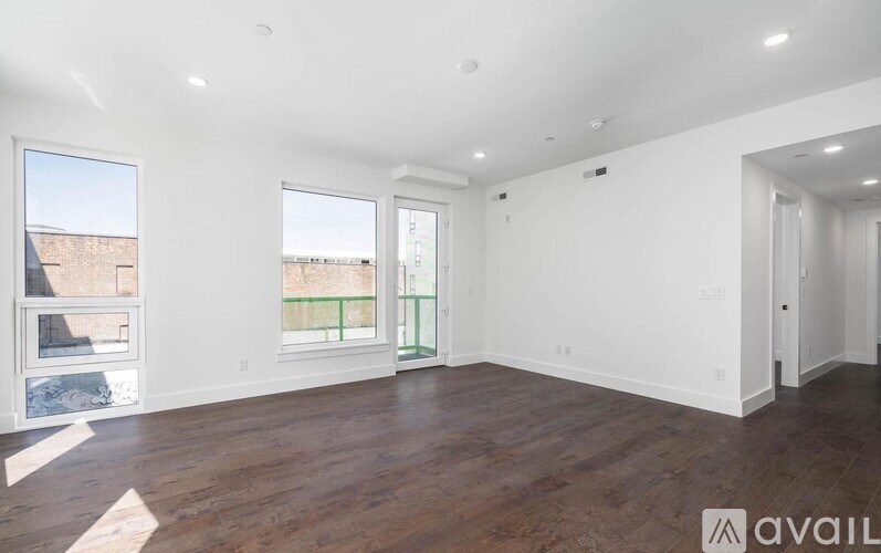 A spacious room with wooden floors and white walls, ready for furnishing.