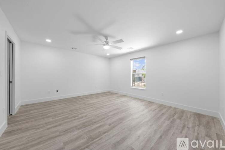 A spacious room with a ceiling fan and a window.
