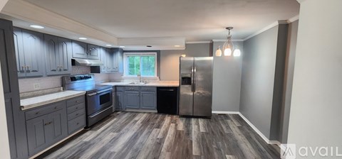 A kitchen with a refrigerator, stove, and cabinets.