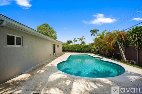 A swimming pool in a backyard surrounded by a fence and trees.