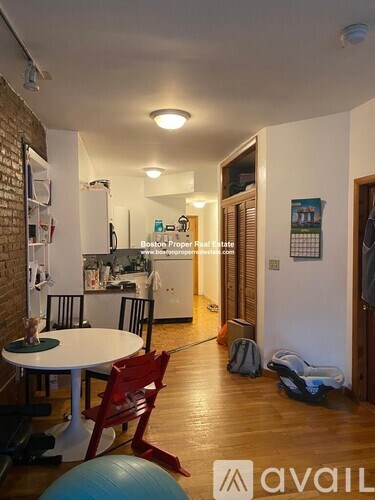 A living room with a table and chairs and a ball on the floor.