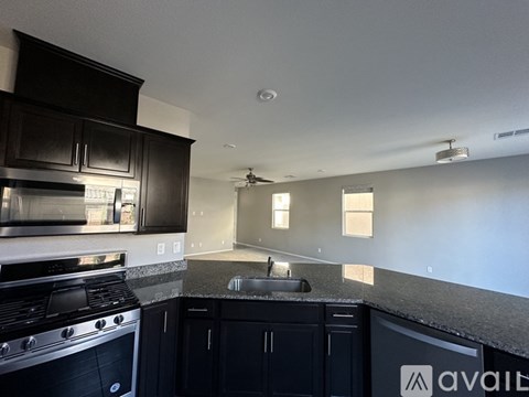 A kitchen with black cabinets and a stove top oven.