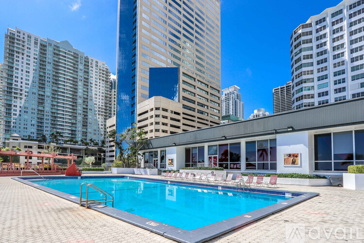 A swimming pool in front of a building with a blue sky in the background.
