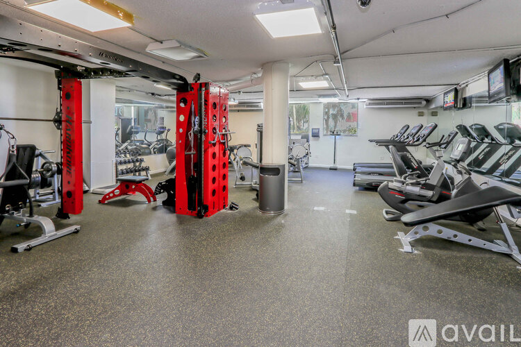 A gym with a variety of equipment including treadmills, weights, and exercise machines.