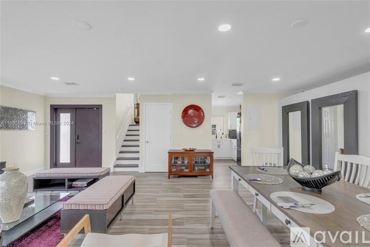 A modern living room with a staircase and a dining area.