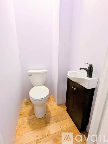 A white toilet sits next to a sink in a small bathroom.