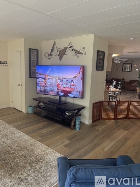 A living room with a television and a blue couch.