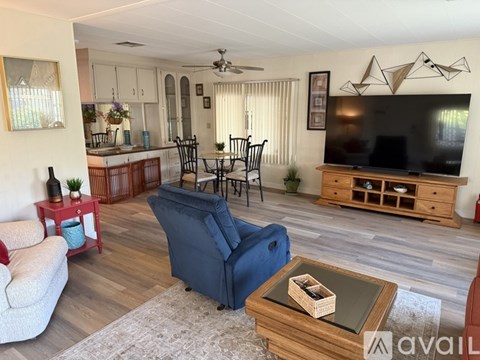 A living room with a blue chair and a wooden coffee table.