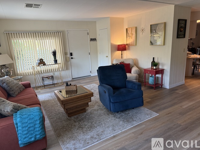 A living room with a red couch, a blue armchair, and a wooden coffee table.