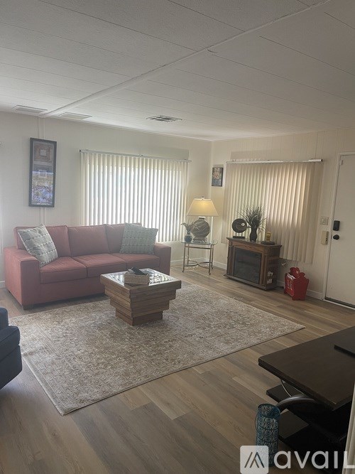 A living room with a red couch, a coffee table, and a rug.