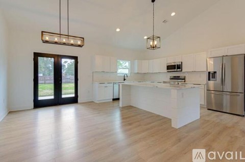 A modern kitchen with white cabinets and stainless steel appliances.