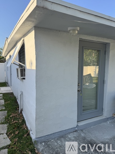 A white house with a grey door and a window.