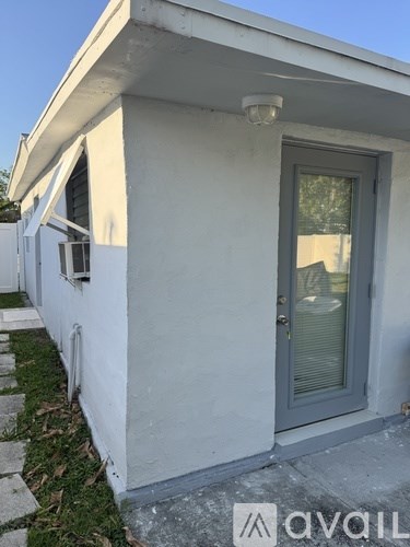 A white house with a grey door and a window.