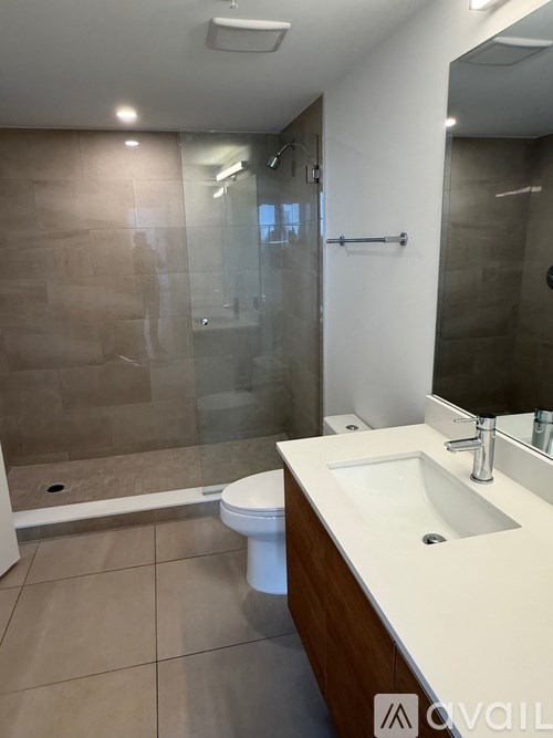 A bathroom with a toilet, sink, and shower.