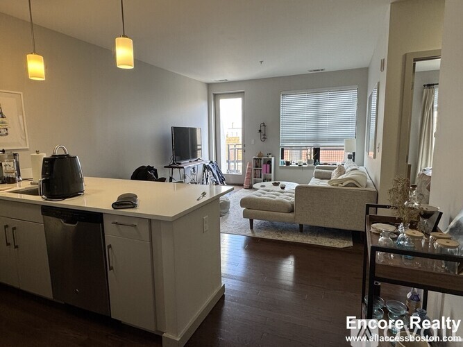 A kitchen with white cabinets and a dishwasher is shown.
