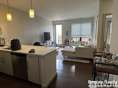 A kitchen with white cabinets and a dishwasher is shown.